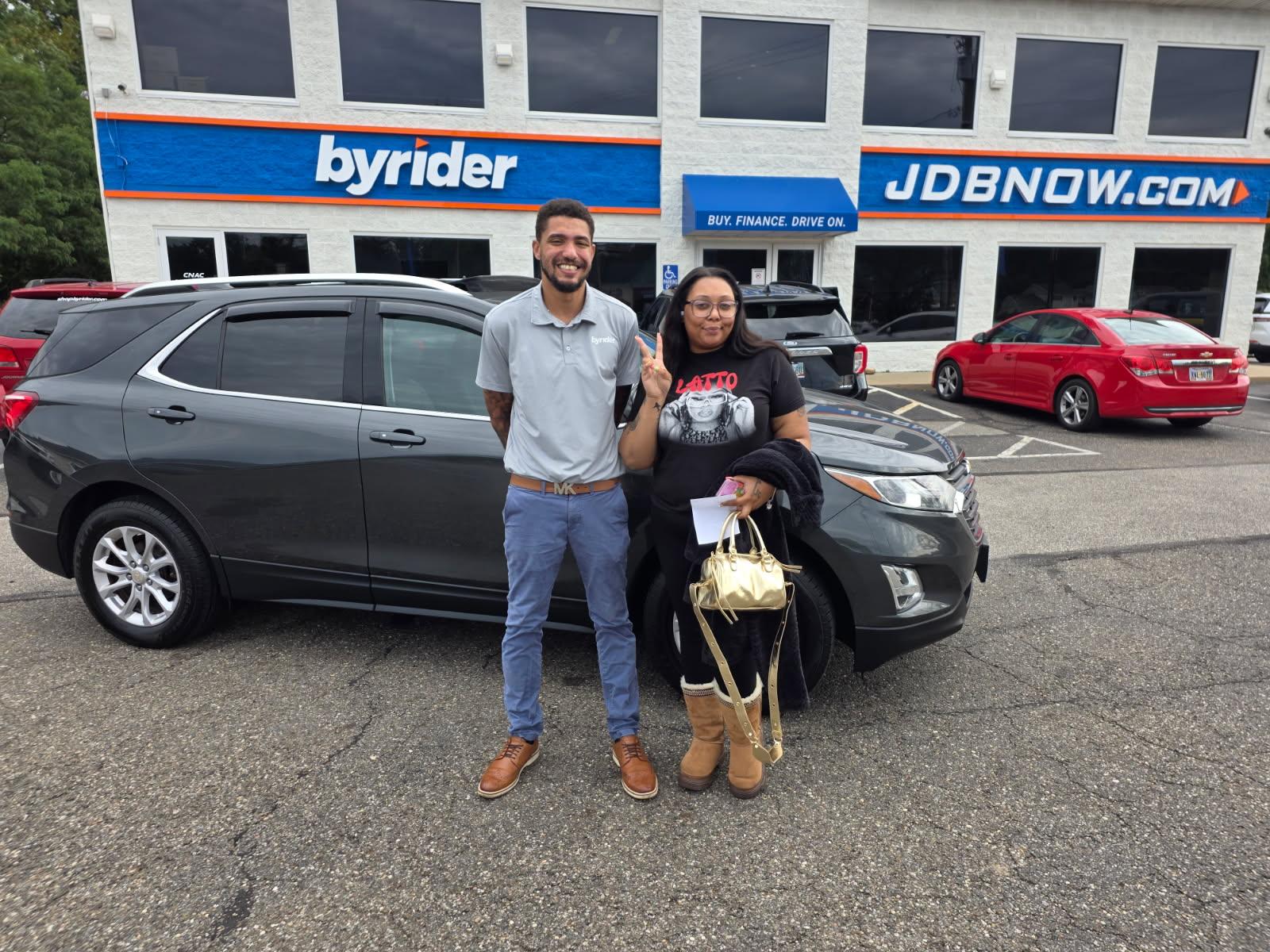 Byrider Akron customers with their used Chevrolet Equinox at the Akron, Ohio dealership
