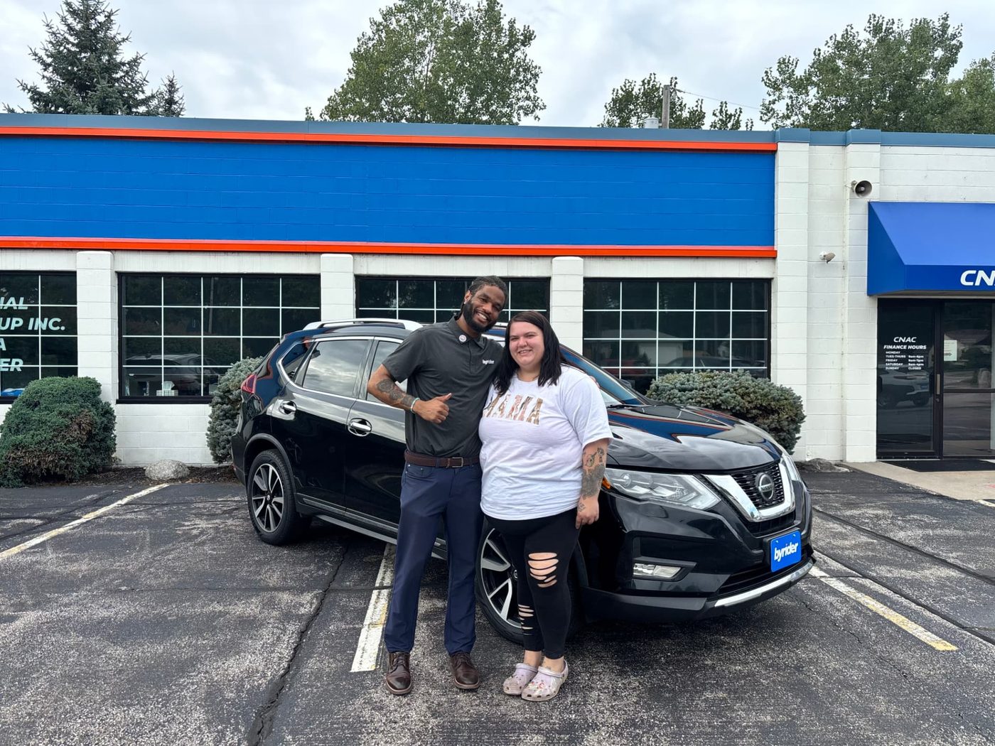 Byrider Amherst customer and salesperson beside their used Nissan at the Amherst, Ohio dealership