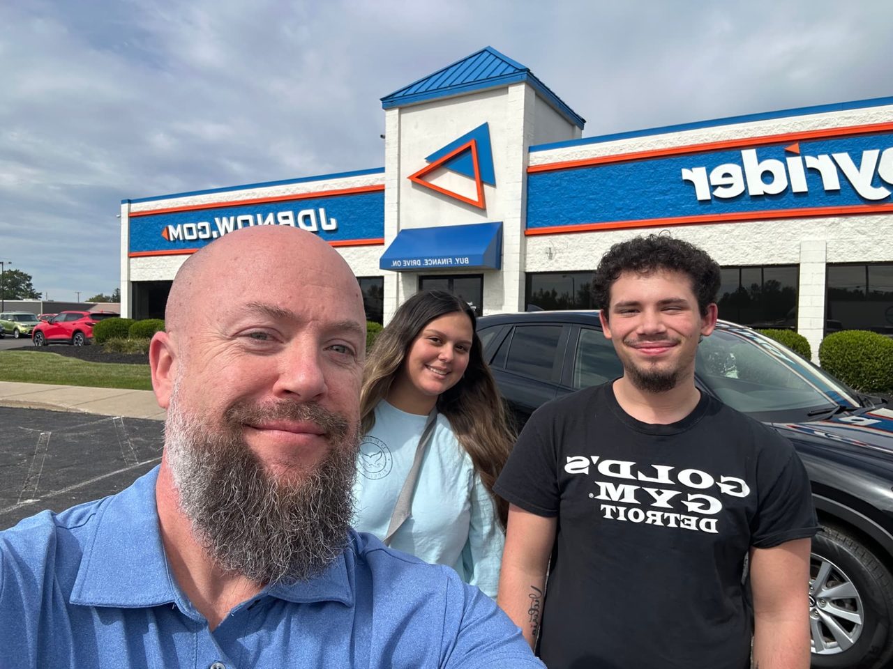 Byrider Mansfield customers and salesperson beside their used vehicle at the Mansfield, Ohio dealership
