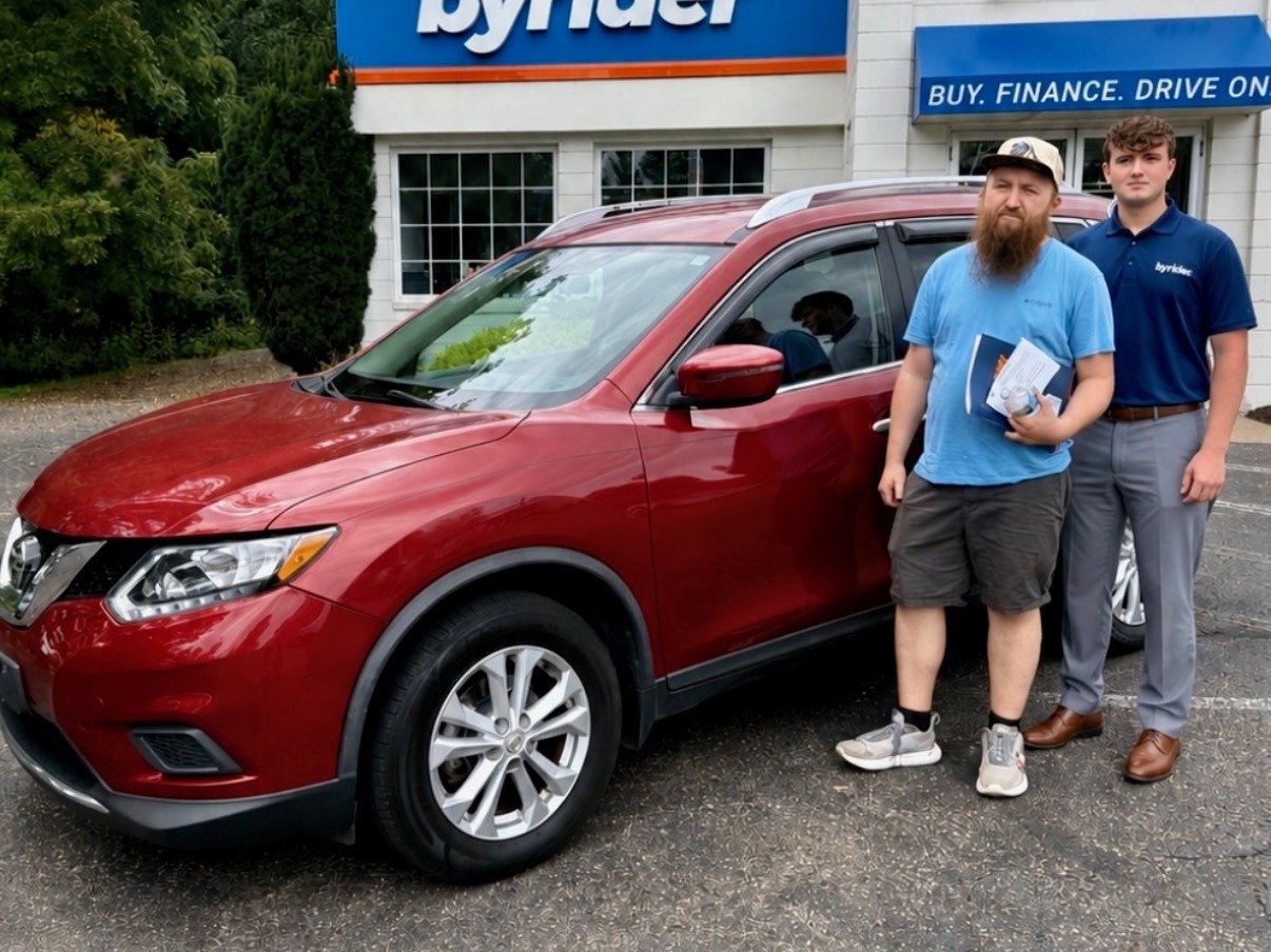 Byrider Wooster customer and salesperson beside their used Nissan Rogue at the Wooster, Ohio dealership