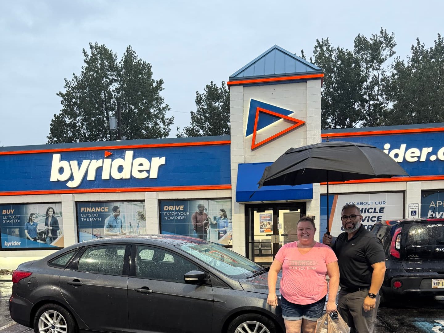 Byrider Amherst customer and salesperson beside their used Ford Focus at the Amherst, Ohio dealership