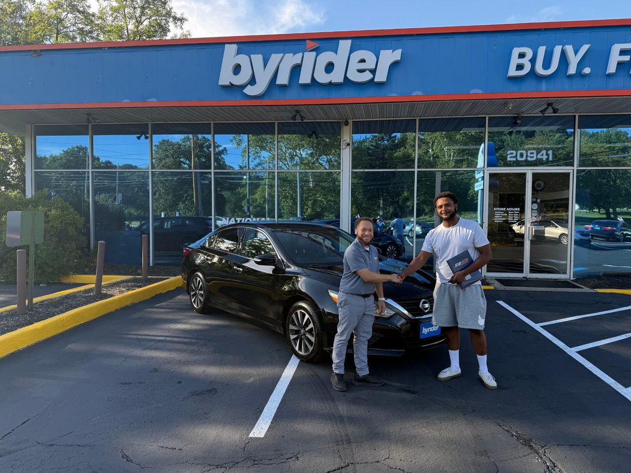 Byrider Euclid customer and salesperson beside their used Nissan Altima at the Euclid, Ohio dealership