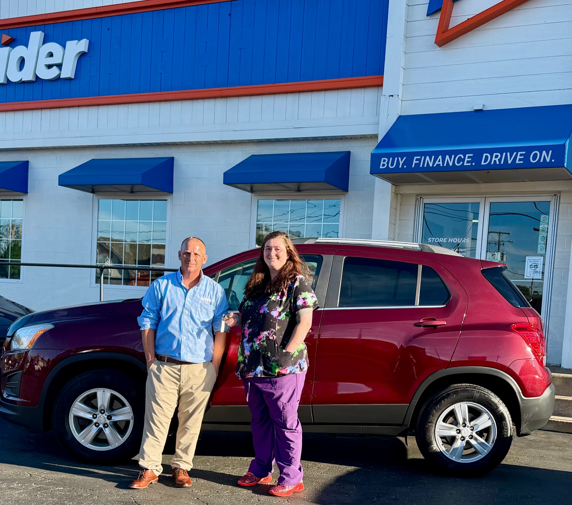 Byrider Canton salesperson and customer beside their used Chevrolet Trax at the Canton, Ohio dealership