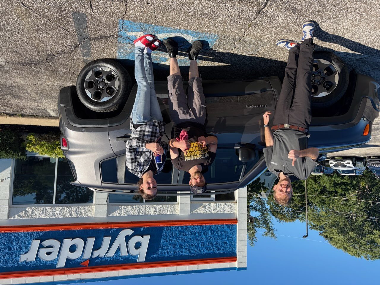 Byrider Ashtabula customers and salesperson beside their used Jeep Renegade at the Ashtabula, Ohio dealership