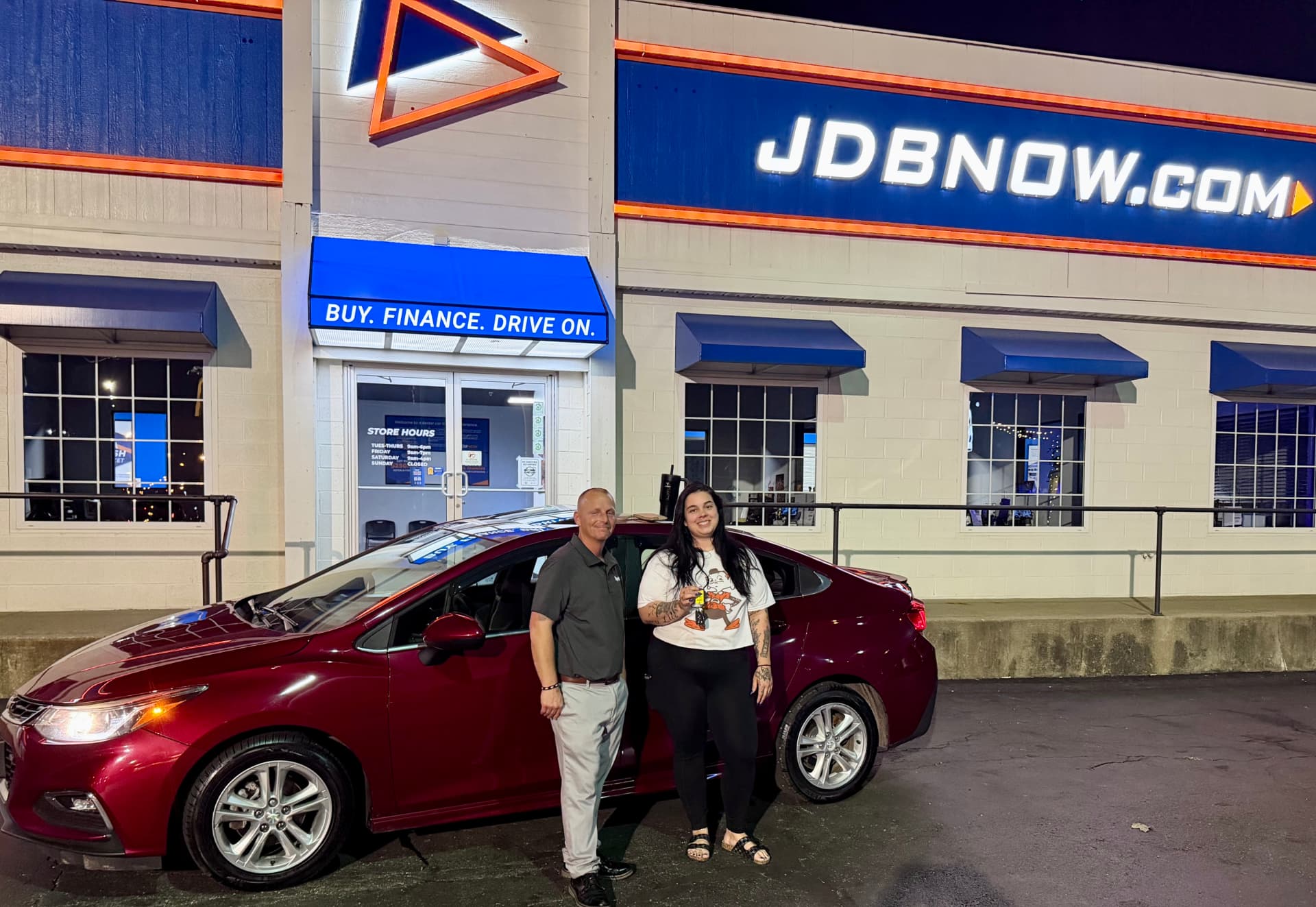 Byrider Canton customer and salesperson beside their used Chevrolet Cruze at the Canton, Ohio dealership