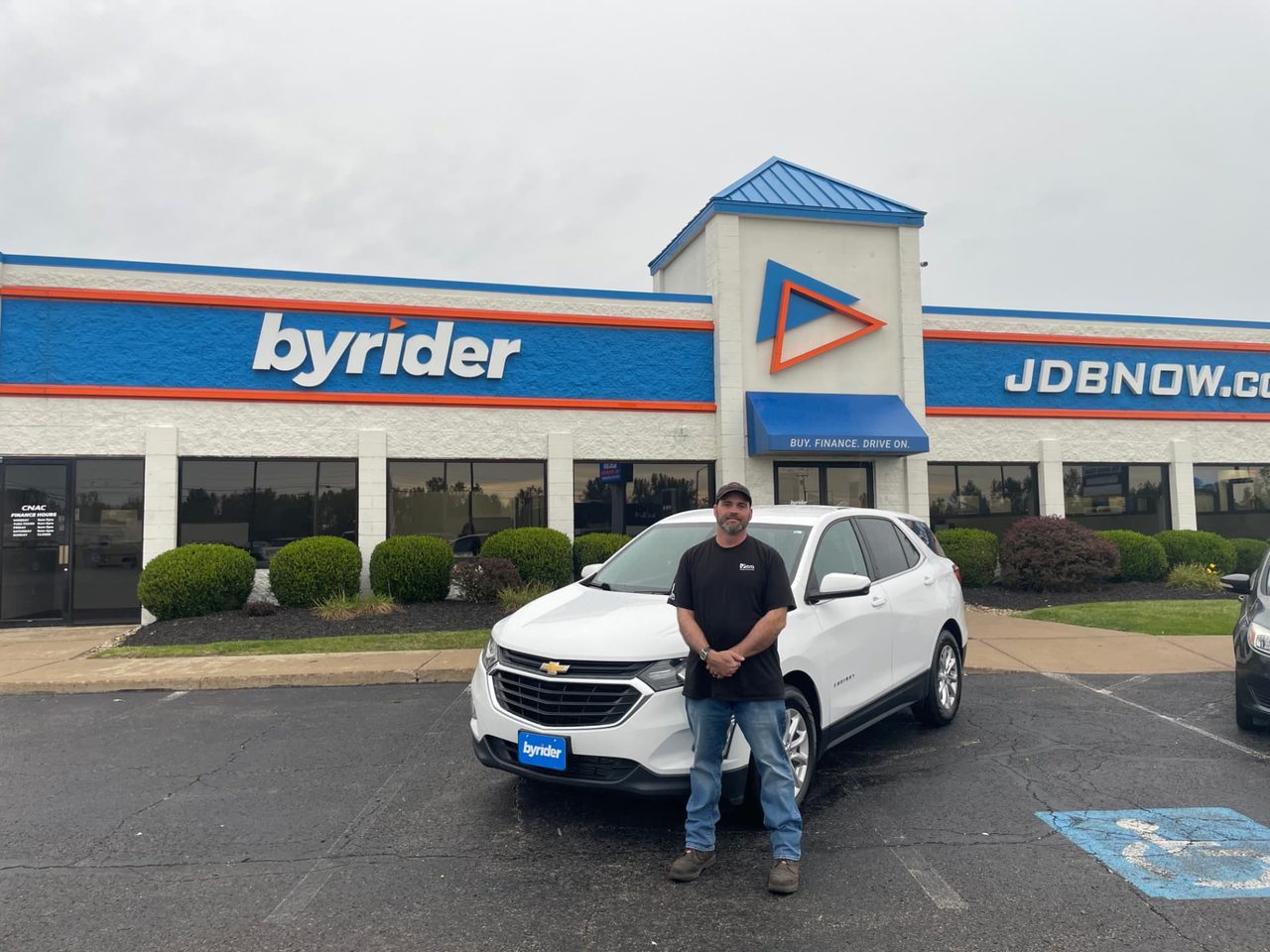 Byrider Mansfield customer beside their used Chevrolet Equinox at the Mansfield, Ohio dealership