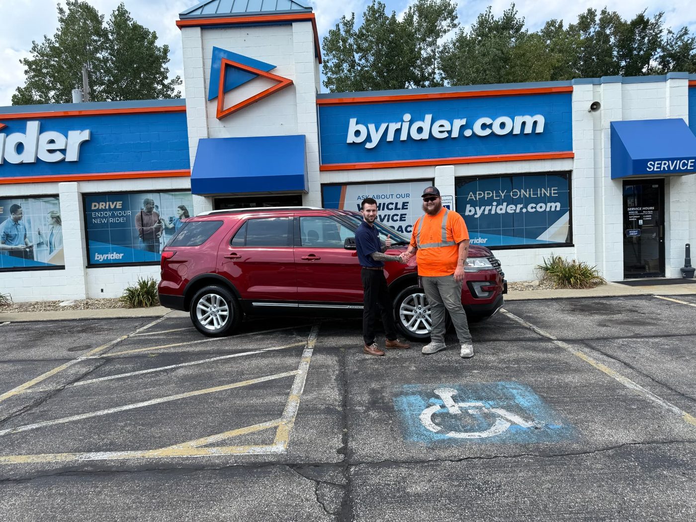Byrider Amherst customer and salesperson beside their used SUV at the Amherst, Ohio dealership