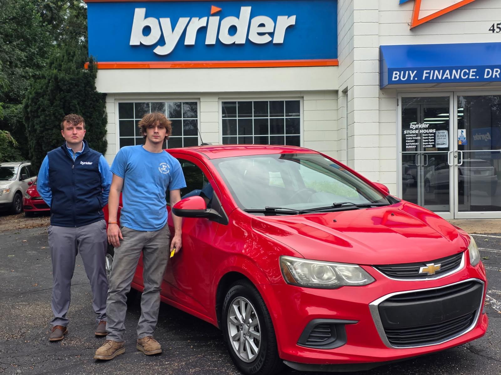 Byrider Wooster customer and salesperson beside their used Chevrolet Sonic at the Wooster, Ohio dealership