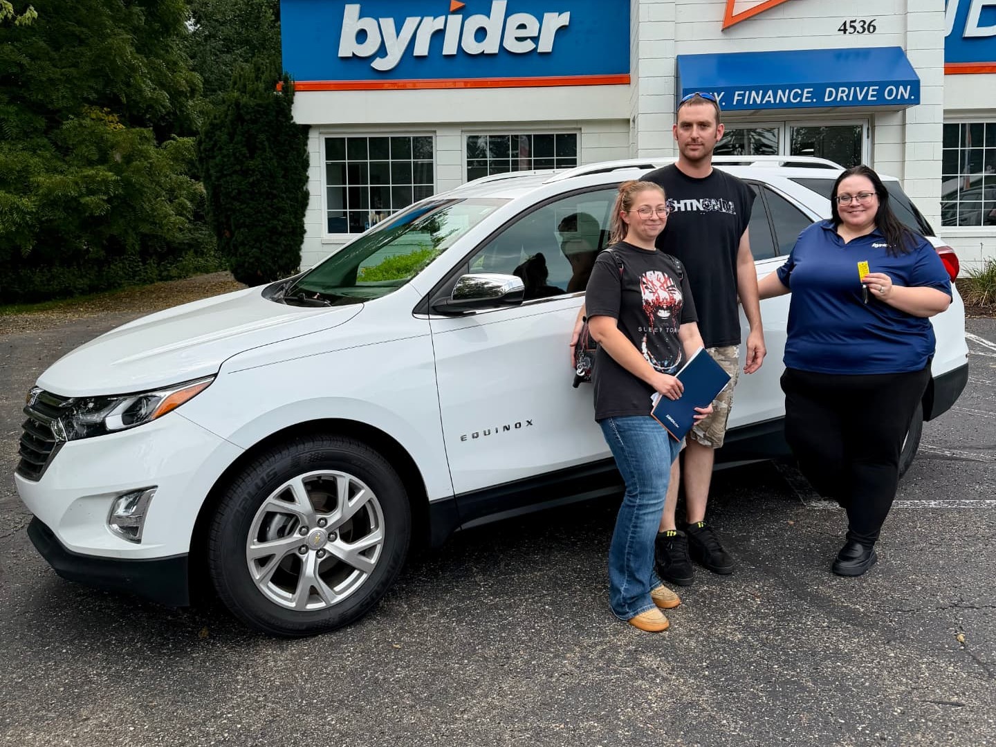 Byrider Wooster customers and salesperson beside their used Chevrolet Equinox at the Wooster, Ohio dealership