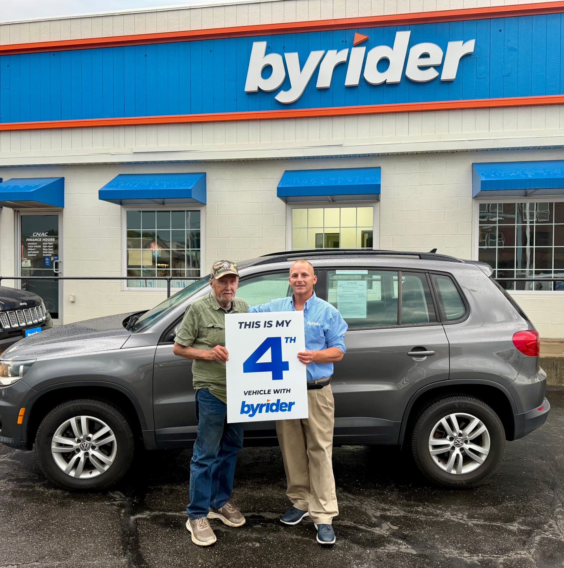 Byrider Canton customer and salesperson beside their used Volkswagen Tiguan at the Canton, Ohio dealership