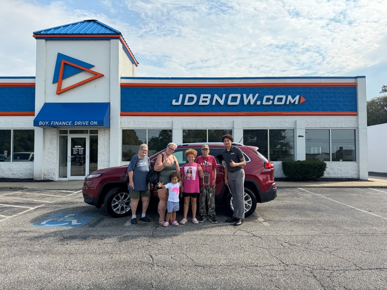 Byrider Ashtabula customers and salesperson beside their used Jeep Cherokee at the Ashtabula, Ohio dealership