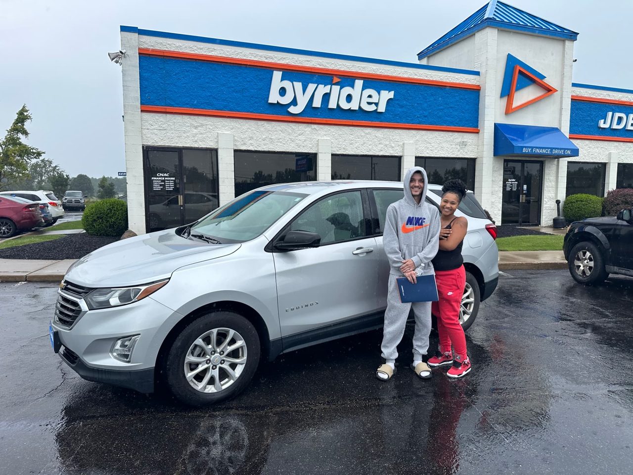 Byrider Mansfield customer and salesperson beside their used Chevrolet Equinox at the Mansfield, Ohio dealership